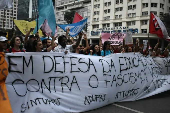 Passeata com faixa "Em defesa da educação, contra o fascismo" e bandeiras de sindicatos e entidades estudantis